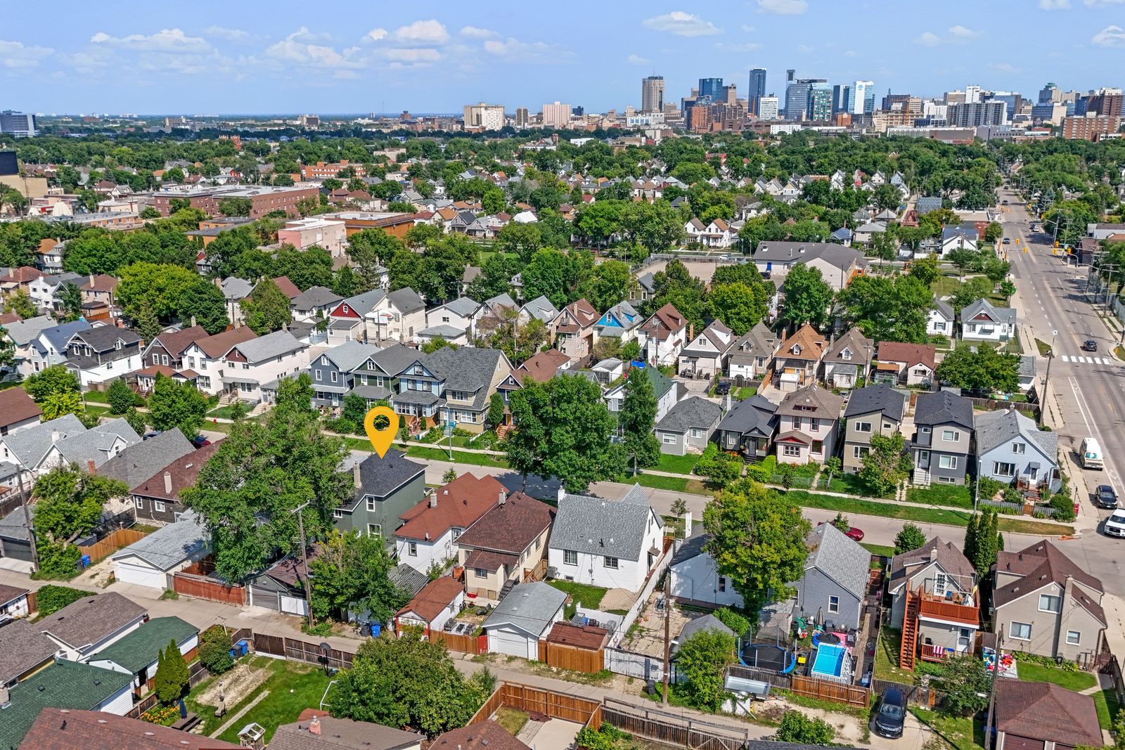 Aerial view of the neighbourhood with the downtown Winnipeg skyline beyond